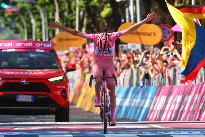 Team UAE's Slovenian rider Tadej Pogacar wearing the overall leader's pink jersey celebrates as he crosses the finish line to win the 20th stage of the 107th Giro d'Italia cycling race, 184km between Alpago and Bassano del Grappa on May 25, 2024. (Photo by Luca Bettini / AFP) (Photo by LUCA BETTINI/AFP via Getty Images)