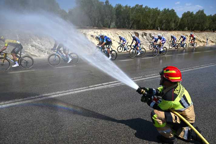 The temperature is around 36°C. The drivers gladly accept the cooling from the fire brigade