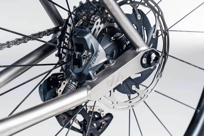 Anpassungsfähig: Ein eingeschweißtes Frästeil nimmt am 8bar Mitte TI Bremssattel und Steckachse auf. Mit dem ovalen Insert lässt sich der Radstand verkürzen.