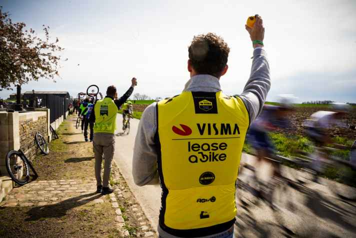 Bei Paris-Roubaix 2024 ist Nathan Van Hooydonck an der Strecke auch als Helfer für seine ehemaligen Teamkollegen dabei. Nach einem Kopfsteinpflasterabschnitt reicht er ihnen Flaschen.