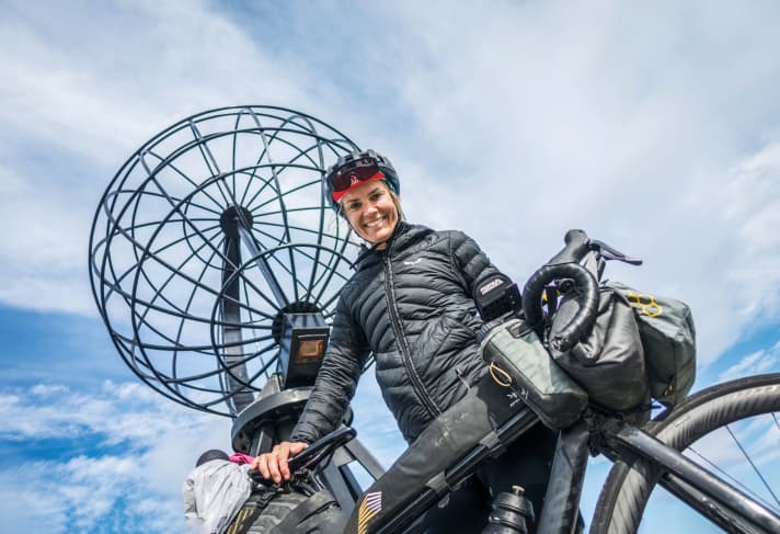 Sara Hallbauer au pied du globe d'acier, l'emblème du Cap Nord