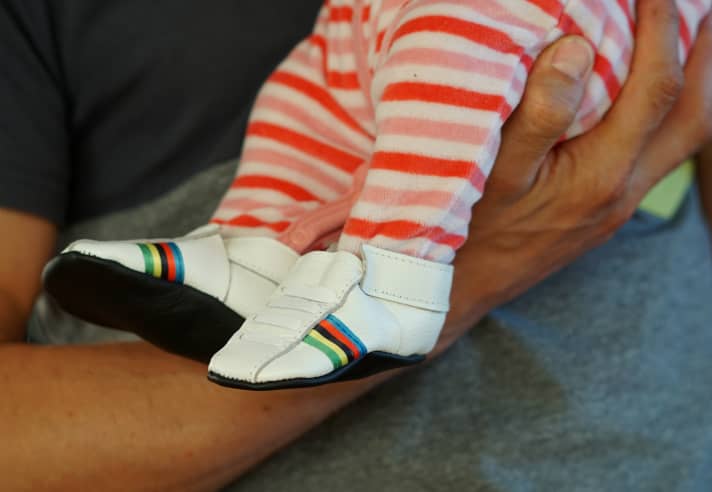   Nino Schurter hat eine Tochter, hier noch als Baby in Schuhen mit Regenbogenstreifen.