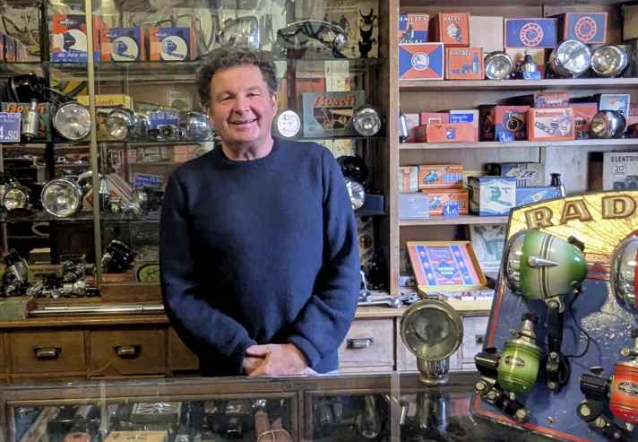 Fahrrad-Enthusiast und Museumsleiter Ivan Sojc im historischen Fahrrad-Laden des Museums, der einen einzigartigen Charme versprüht. Die Regale sind bis unter die Decke gefüllt mit Fahrrad-Zubehör wie Sättel, Mäntel, Schläuche, Ventile, Lampen und Klingeln.