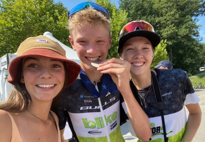 Team-Freude: Paulina (links) und Lucie (rechts) freuen sich mit Elias über seine Silbermedaille bei der Jugend-EM in der Schweiz.