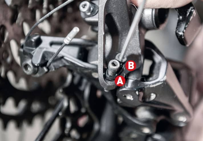   Mit den beiden Anschlagschrauben (im Bild A und B bei einem Shimano-Schaltwerk) kann man den Schwenkbereich des Schaltwerks begrenzen.