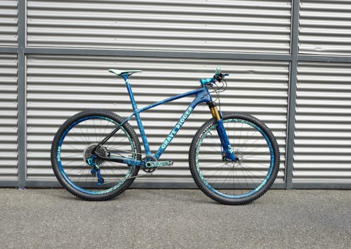 Grave Digger heißt Totengräber, doch das muss man bei dieser Grafik eigentlich nicht erwähnen. Das ganze Bike ist mit Totenköpfen verziert. Alles per Transferdruck aufgebracht. Auf die Kurbeln, die Felgen, die Stütze, den Lenker, die Fox und natürlich auch auf den Rahmen.