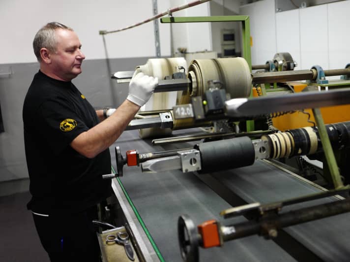   Spools, conveyor belts, winding machines: The metre-wide rubber sheets from the calender machine are portioned to the required widths and rolled up again.
