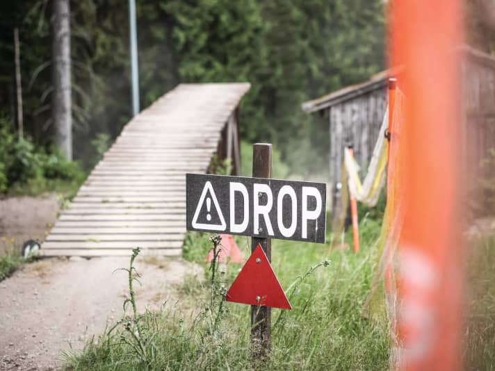 Suche Dir einen guten Drop zum Lernen mit maximal 0,5 Meter Höhe und einer langen, breiten Landung mit etwas Neigung.