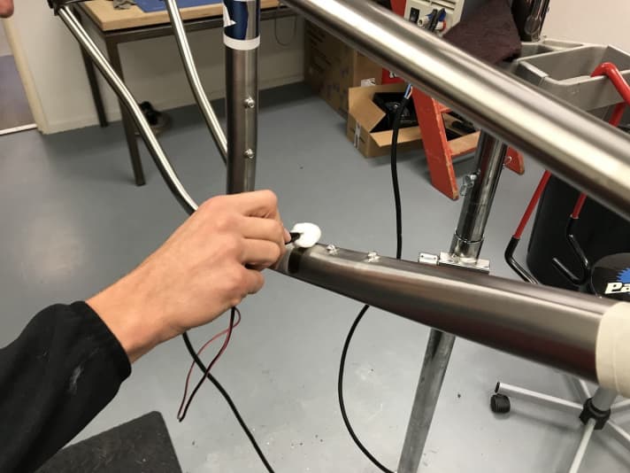   And this is how it works: First, the areas that are to be coloured are masked off. Then the actual anodising begins: The frame is placed under tension. The areas that are to be coloured are then dabbed with a conductive liquid.  
