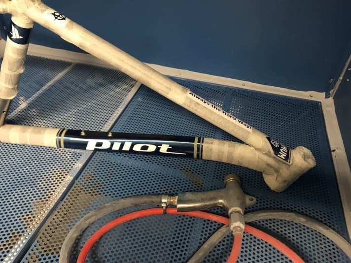   Jetzt kommt der Rahmen in die Sandstrahlkabine. Die Stellen, die jetzt noch nackt sind, werden nach der Behandlung ein raues Finish haben. Das Blau wird verschwunden sein. Bis auf die Stellen, die abgeklebt sind. 