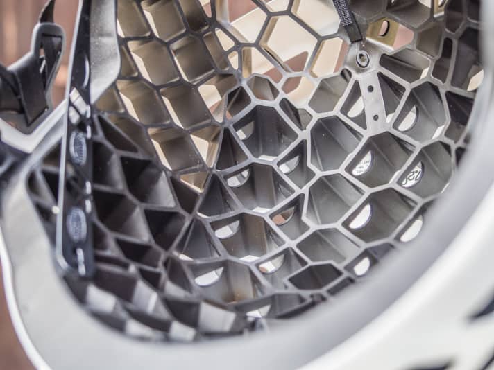   Die Elastomer-Struktur ist nur an wenigen Punkten mit der Polycarbonat-Schale verbunden und soll sich dadurch bei Stürzen stärker verformen.