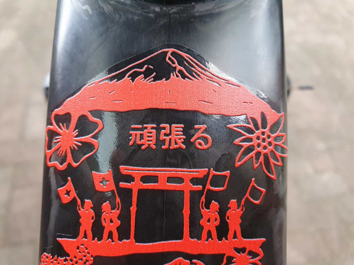   Im Rahmendesign verschmelzen Elemente aus Japan, wie der Mount Fuji, mit Scherenschnitten der Schweizer Künstlerinnen Elvira und Esther Gerber, die Schweizer Traditionshandwerk zeigen.