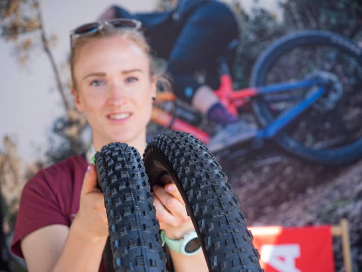 Kenda PR woman Pia Übelein holds the new Rush and Karma 2 tyre models up to the camera.