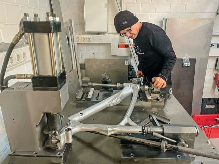 Jürgen Schlender positions everything on the frame jig. Later, our 29er mountain bike will have 160 millimetres of rear suspension travel. The rear triangle is designed for 27.5 inches (called MX or Mullet) because Alutech can do without carbon struts, which in turn have to be imported from the Far East. The boss personally welds these struts. | h.
