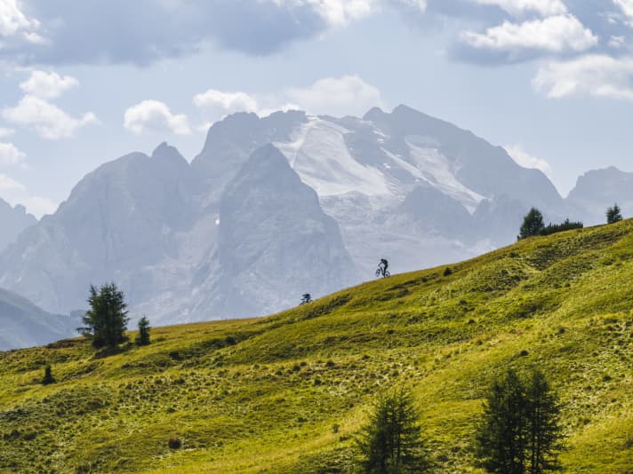 Ganz oben rumpelt noch viel Geröll unter den Reifen, danach geht’s fast lautlos durch Almwiesen dahin. Die Strada de la Vena mit Blick auf die Marmolada.