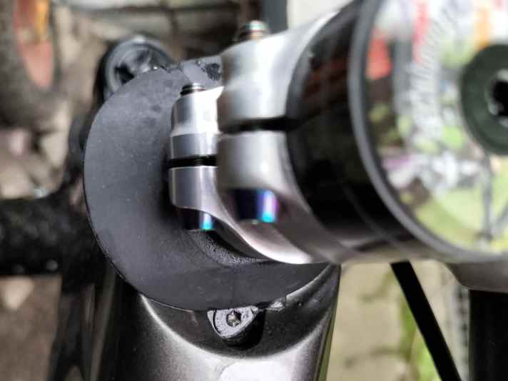 Water collects at this point. The oval headset cap exposes the screw of the stop limiter when the handlebars are turned.