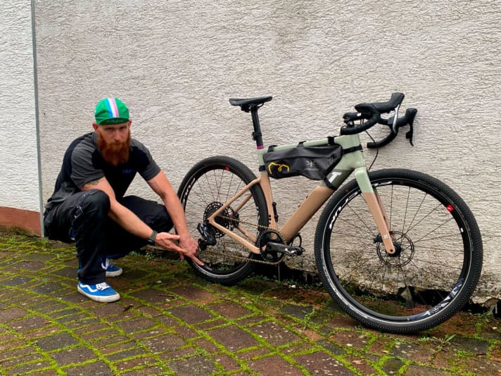 Benjamin Spahn deutet auf den an Luft verlierenden Hinterreifen.