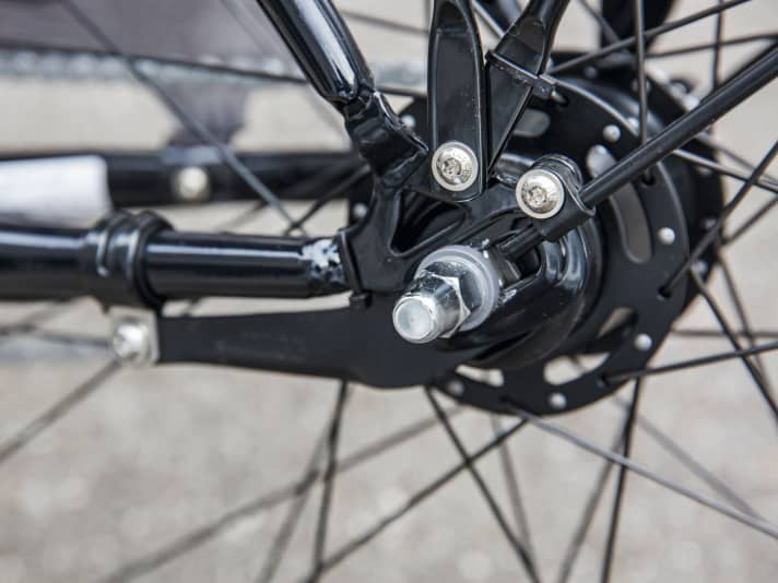 Die Kettenspannung wird durch Verschieben der Radachse in den schrägen Ausfallenden reguliert. Dabei verkantet die Achse leicht, sie kollidiert hier zudem mit den Blechstreben.