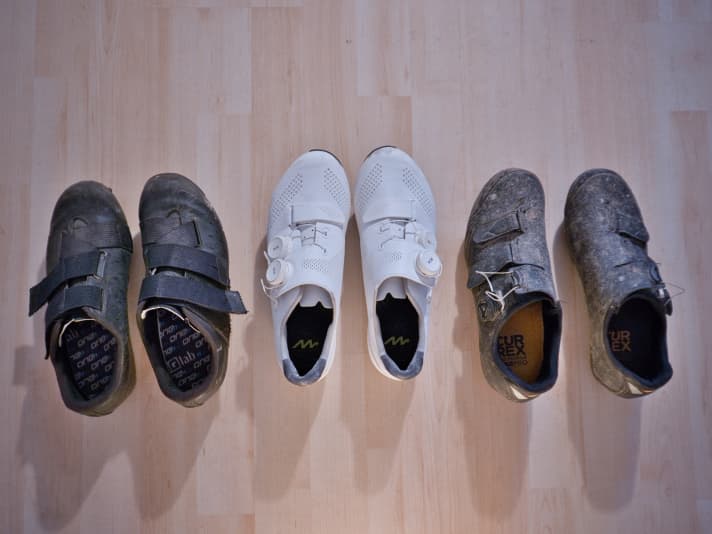 Alte Gravelschuhe (links), die abgelaufene Sohle ist zu gefährlich für draußen, noch gut für’s Rollentraining; saubere und luftige Rennradschuhe (Mitte), auch gut für Indoorradtraining, dreckige MTB-Schuhe sollten erst geputzt werden, bevor es los geht.