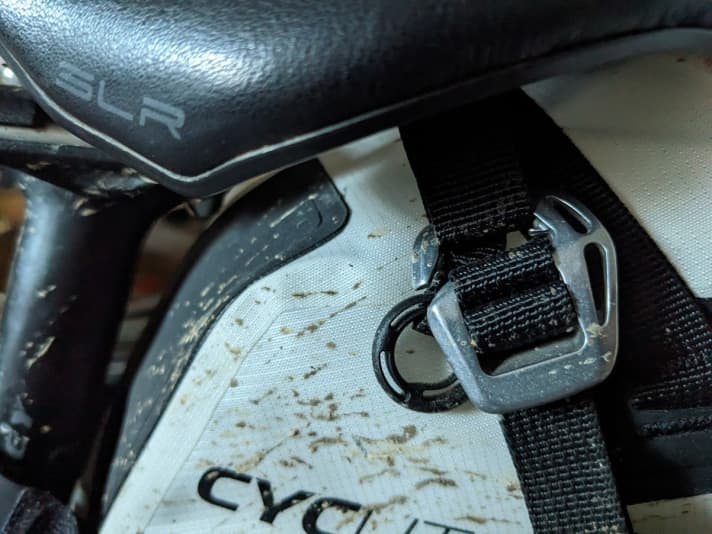 There is no need to thread a thick buckle under the saddle, just a strap. The aluminium hook is then attached.