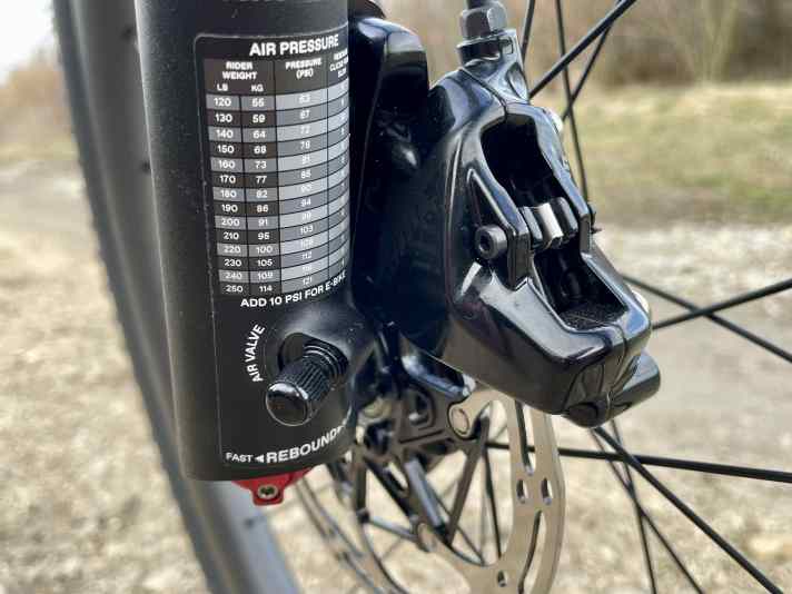 Une valve Schrader permet d'adapter le cylindre d'air intégré de la fourche à suspension au poids du cycliste. La dureté du ressort peut également être ajustée à l'aide d'un petit bouton rotatif.