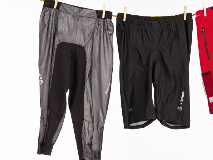 Links die 3/4-lange Fahrrad-Regenhose von Endura, rechts das wasserdichte Überzieh-Modell für Regentage von Löffler.