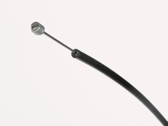 Der Bowdenzug besteht aus einer schwarzen Kunststoffhülle und dem Stahlkabel, das den Schaltzug bildet.