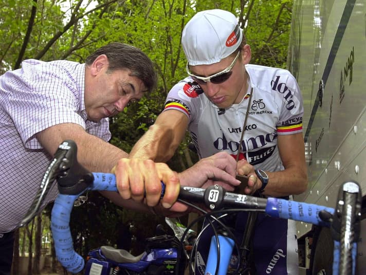 Eddy Merckcx (à gauche) inspecte le vélo de son fils Axel Merckx lors du Tour de France 2001.