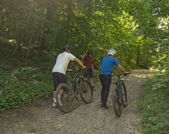 Im Bikepark Weingarten gibt’s keinen Lift, wir schieben hoch. „Oder sollen wir doch noch mal zurück zu dem Hip-Jump?“, fragt Korbi.