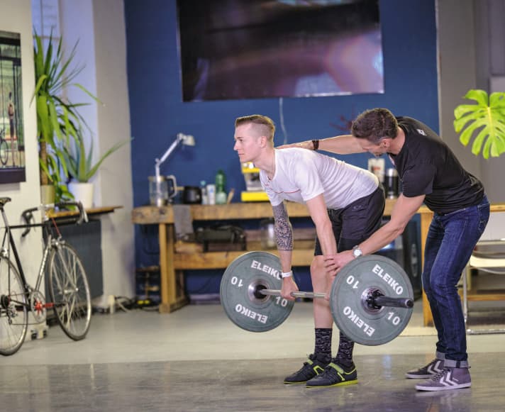 Entraînement de la force pour les cyclistes : l'entraîneur Andreas Wagner montre à son protégé, le coureur d'élite Constantin Kolb, ce qui est important dans l'entraînement aux haltères