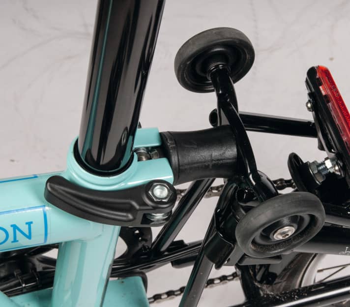 Elastomer rear shock absorber and "auxiliary wheels" for parking and rolling the folded wheel