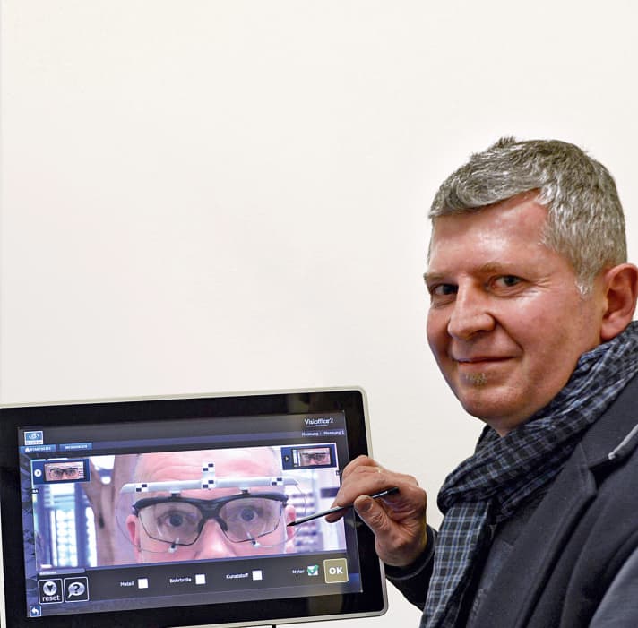   Customised work: sports optician Helmut Reinthaler adjusts athletes' glasses while they are sitting on an adjustable bike. He uses a camera system and special software to determine the grinding-in position.
