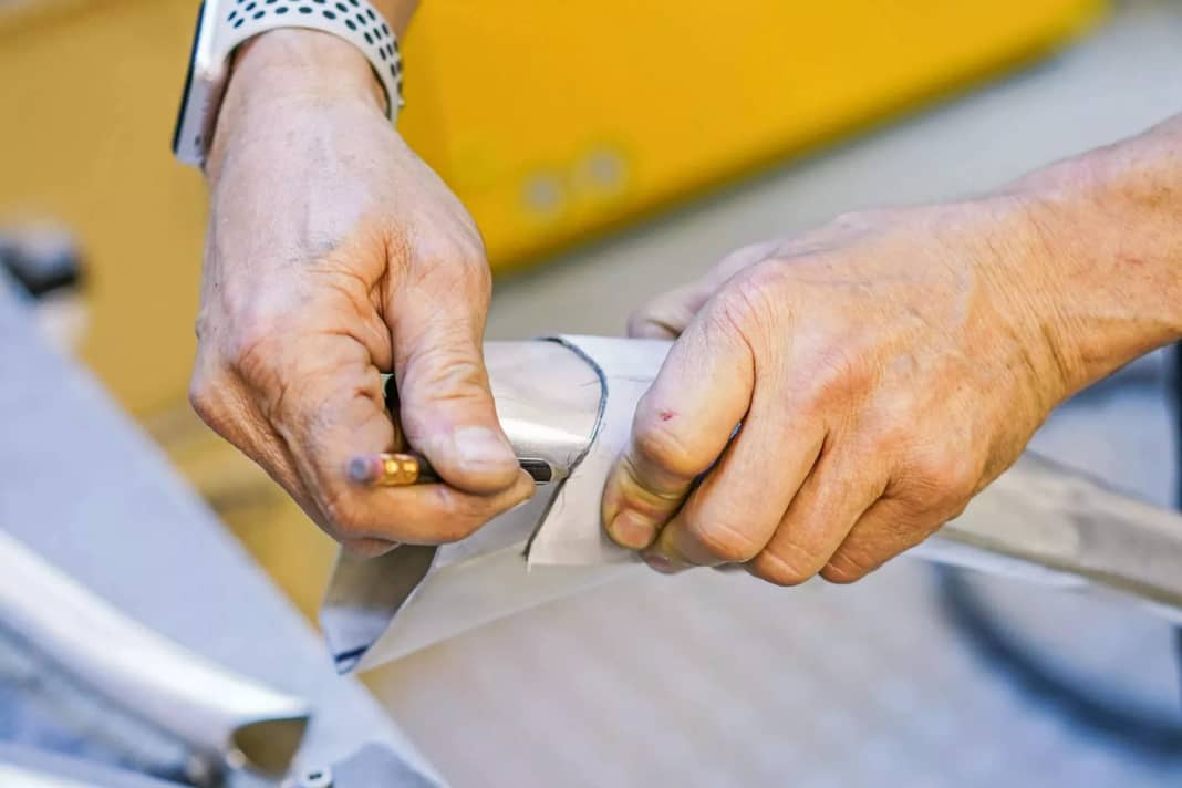 Mit Bleistift und Schablone zeichnet Jürgen Schlender die Schnittkanten an. Ähnlich, wie es ein Schneider mit Stoffen macht. Entlang der Linie schneidet er das Rohr dann mit der elektrischen Hand­säge in Form.