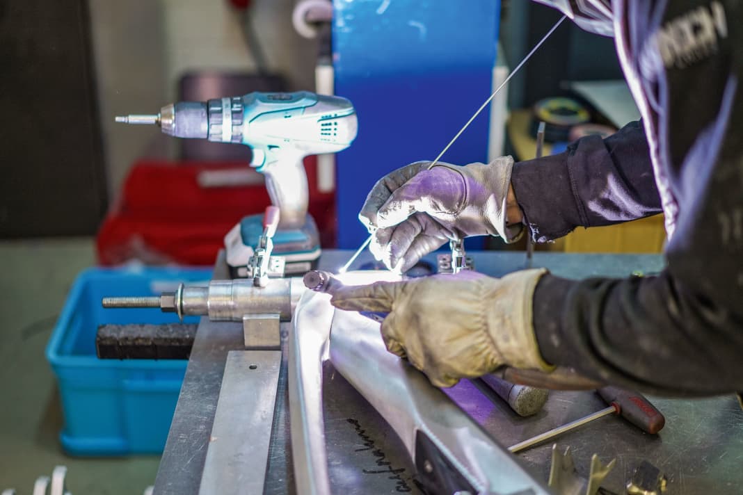 Kaltes Aluminium wird mit einer mehrere hundert Grad heißen Elektro-Nadel zum Schmelzen gebracht, um es zu einer Einheit zu verbinden.