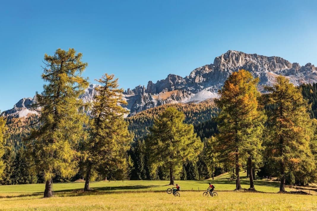 Relaxed autumn biking under the Latemar. On the mountain pastures of Obereggen, the famous mountain massif comes into view for the first time, here with the Reiterjoch peak.