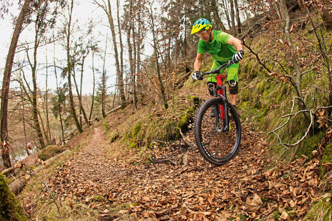 Approach: You should already scan the bend on the approach. How tight is it, what is the surface like, what is the exit like? Reduce your speed to walking pace. Fix the point at which you want to bring the front wheel to a stop. Your legs and arms are slightly bent. The body position is central, the saddle is fully lowered. | WRONG: Body position too rear-heavy, resulting in loss of control