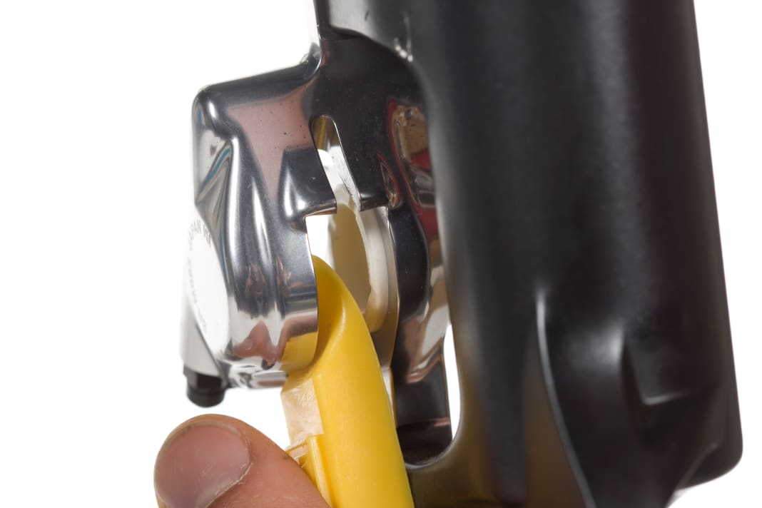 After bleeding, it is advisable to clean the brake pistons. To do this, remove the spreader block. Use a sturdy tyre lever to press against one of the two pistons and actuate the brake lever until the free-standing piston has moved about two millimetres out of the calliper. If you push the piston out too far, it may fall out of the housing.