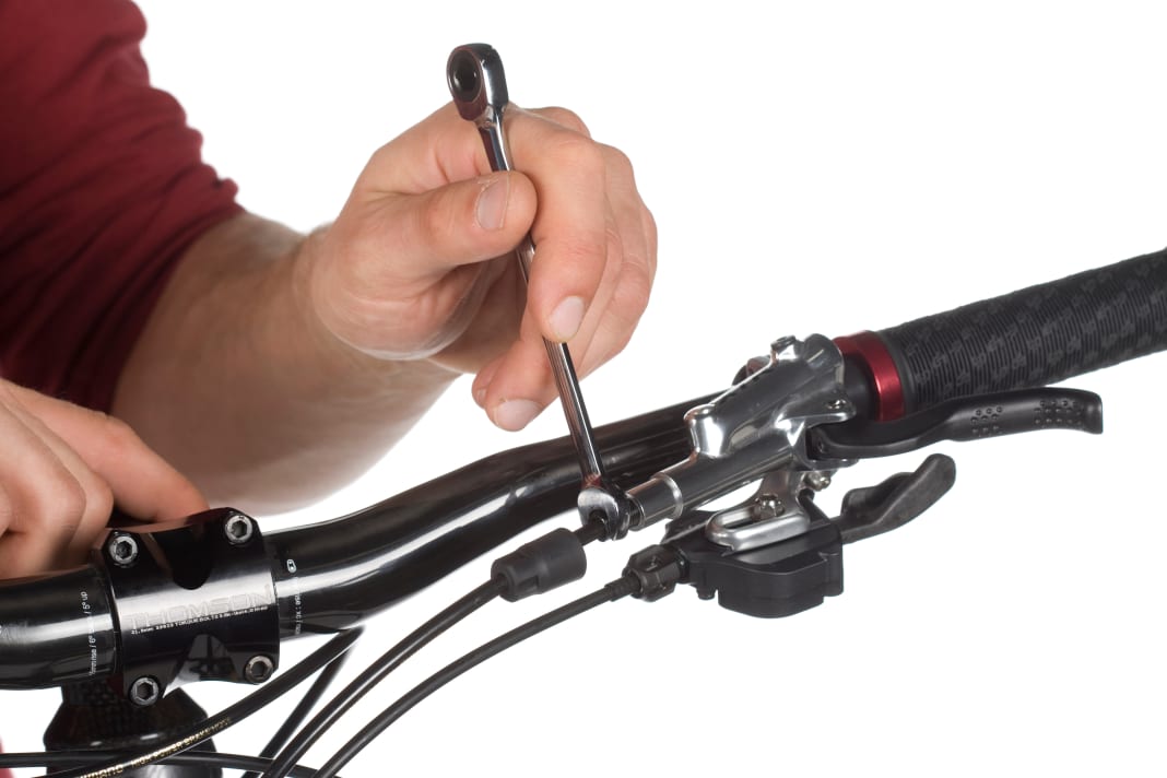Remove the protective cap to access the fastening screws. Then loosen the fastening screw with an 8 mm open-end spanner.