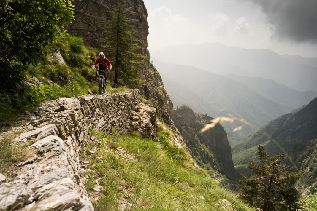 Tatsächlich scheint der Pfad die vertikale Felswand zu durchqueren. Er zieht sich wie eine überdimensionale Narbe über den Stein.
