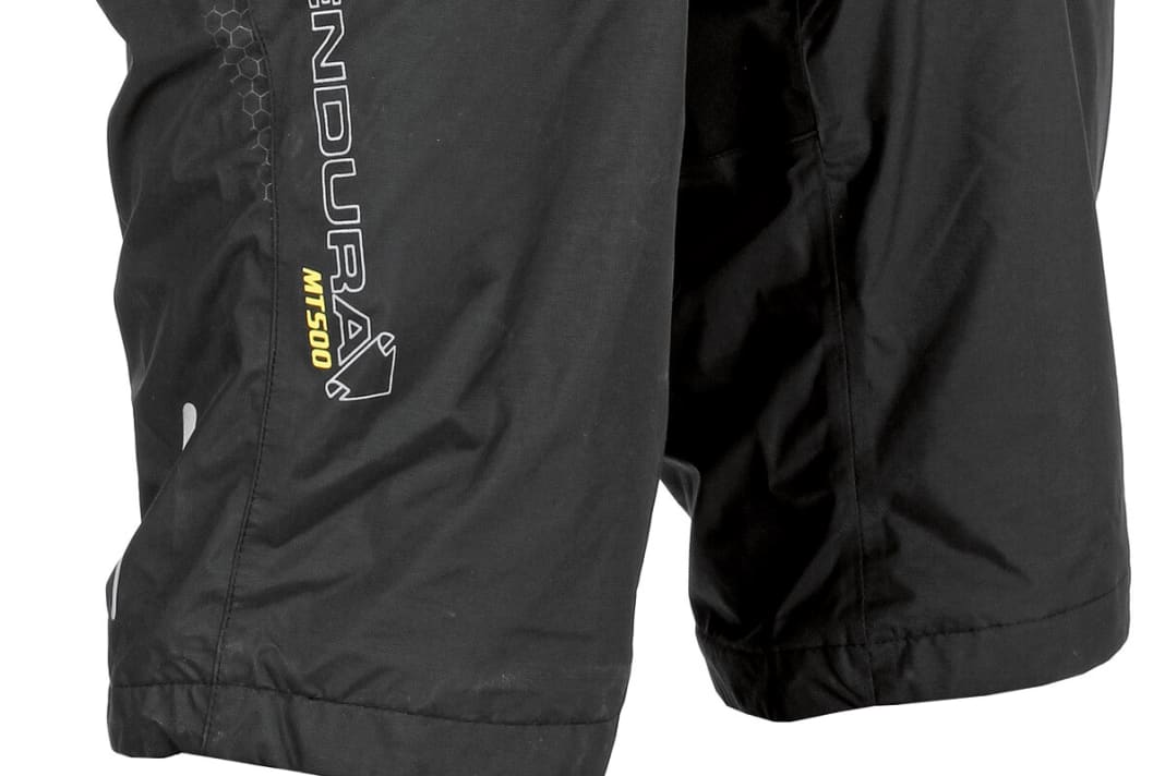 Endura MT500 Waterproof Short: Robuste und gut verarbeitete Regenhose mit toller Passform. Die Membran hält dicht, an den Nähten und im vorderen Schritt am Softshell-Einsatz dringt Wasser ein. Die MT500 endet kurz vorm Knie, lässt sich gut verstellen und rutscht dank Stretch-Einsatz kaum nach unten. BIKE-Urteil: Sehr gut