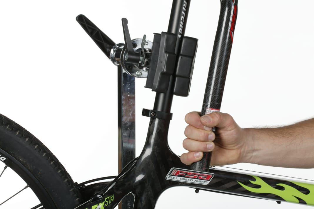 1. BIKE EINSPANNEN

Montageständer mit Klauenmechanismus sind ungeeignet. Wegen der Hebelverhältnisse werden die Carbon-Rohre darin leicht zerdrückt! Besser: Ständer mit Drei- oder Vierpunktaufnahme, oder stecken Sie eine metallene (fettfreie) Sattelstütze in das Sitzrohr. Am besten eignet sich eine billige Montage-Sattelstütze.
