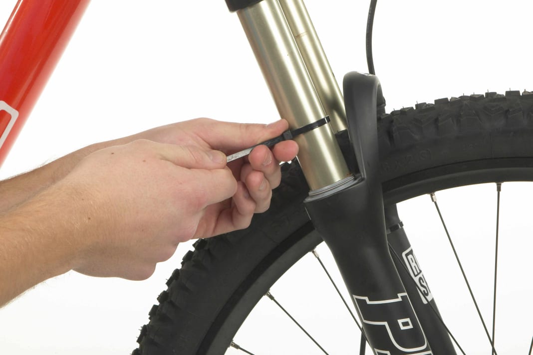 1. tie a cable tie around one of the fork legs. The cable tie fulfils the same function as the rubber ring on the damper: as a marker to determine the negative suspension travel (sag).