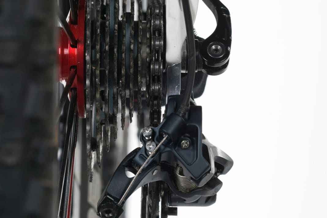 1. derailleur hanger There are three screws on the way to a perfectly adjusted derailleur. But before you start with the fine adjustment, you should check whether the derailleur hanger is really straight. When looking from behind, the derailleur cage must be exactly parallel to the sprockets of the cassette. If the derailleur hanger is bent, the only remedy is usually to replace it or straighten it with special tools.