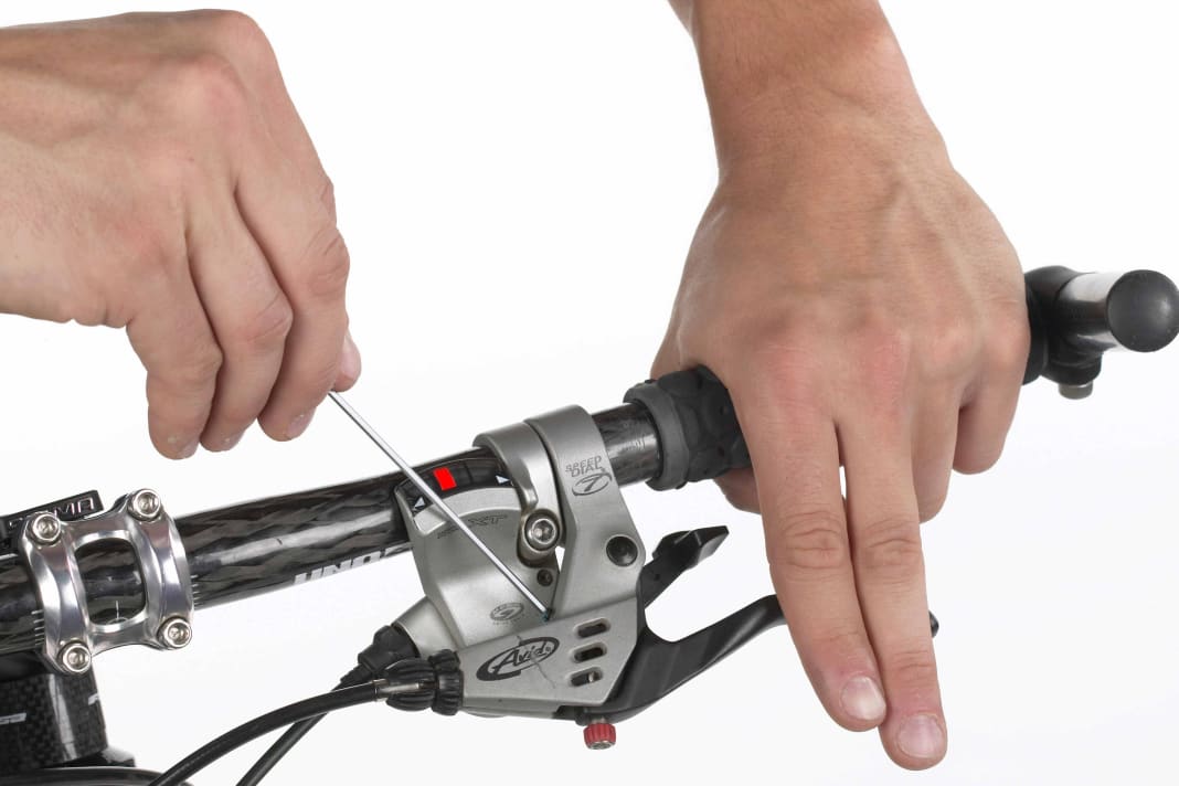 1. HEBELPOSITION UND GRIFFWEITE Wer ergonomisch greift, spart viel Kraft. Gerade auf langen Abfahrten ermüden die Hände langsamer, wenn die Griffweite stimmt. Fast alle V-Bremsen haben dafür eine Stellschraube. Mit einem Inbus-Schlüssel (Größe 2/2,5 oder 3) die Schraube so weit verdrehen, dass der Hebel kurz vor dem mittleren Fingergelenk steht.