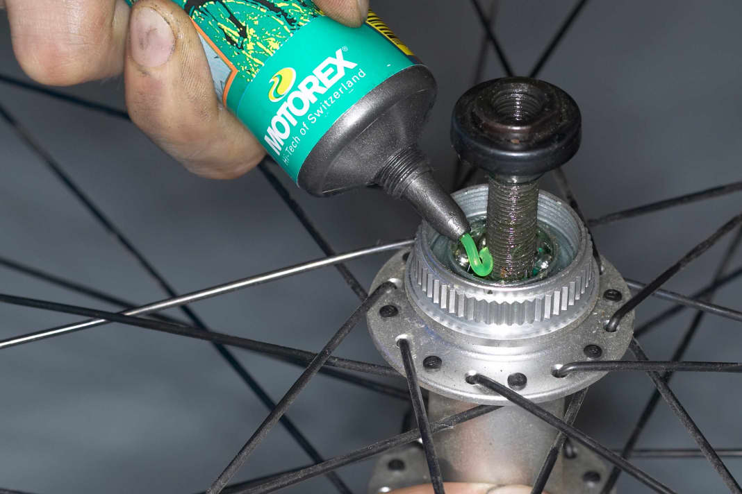 NABEN PFLEGEN
Schritt 1: Achslager schmieren

Die Schmierung der Lager ist meist nur bei Shimano- Naben nötig. Hat ihre Nabe eine “Centerlock”- Befestigung für die Bremsscheibe, sollten Sie die Bremsscheibe demontieren. Öffnen Sie die Konterung der Naben. Entfernen Sie Kontermutter, Distanzscheiben und Lagerkonus. Dann können Sie die Achse herausziehen. Befreien Sie die Lagerlaufflächen und Kugeln von altem Fett und Dreck. Danach setzen Sie die Kugeln wieder ein und belegen sie mit einer frischen Fettpackung. 