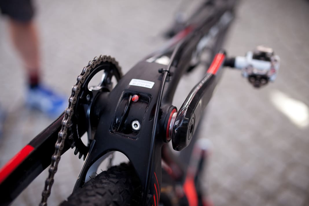 Wenn man die Carbon-Abdeckung unterm Tretlager abschraubt, sieht man die Zugführung für Umwerfer von SRAM, bei denen der Zug von unten angelenkt wird.