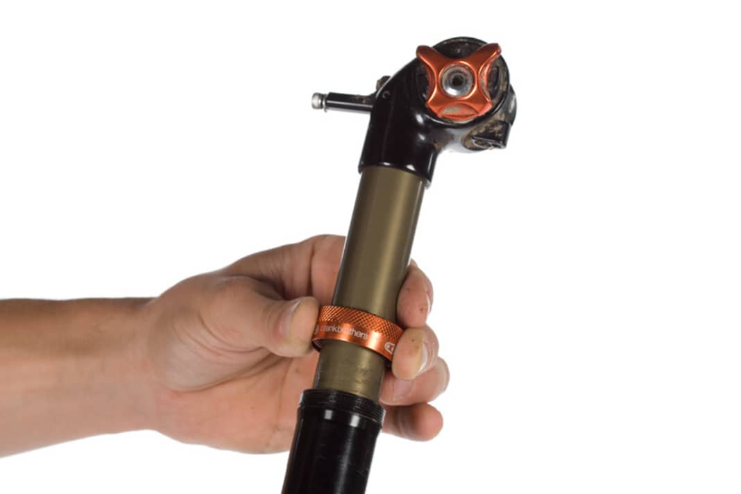 Überwurfmutter lösen:
Mit der Hand schrauben Sie die orangene Überwurfmutter lose und schieben sie nach oben weg. Mit einem 10-Millimeter-Steckschlüssel entfernen Sie die Bodenmutter auf der Unterseite der Stütze (im Inneren des Rohrs).