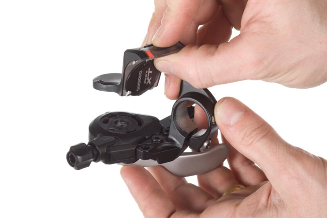 Anzeige abbauen
Eine gemeinsame Schelle für Schalthebel und Bremse à la SRAM gibt es bei Shimano derzeit nicht. Wenn man jedoch die Ganganzeige vom Shifter abmontiert, kann man den Hebel auf beide Seiten des Bremsgriffs montieren. Mit Anzeige passt der Shifter nur innerhalb des Bremsgriffes an den Lenker.