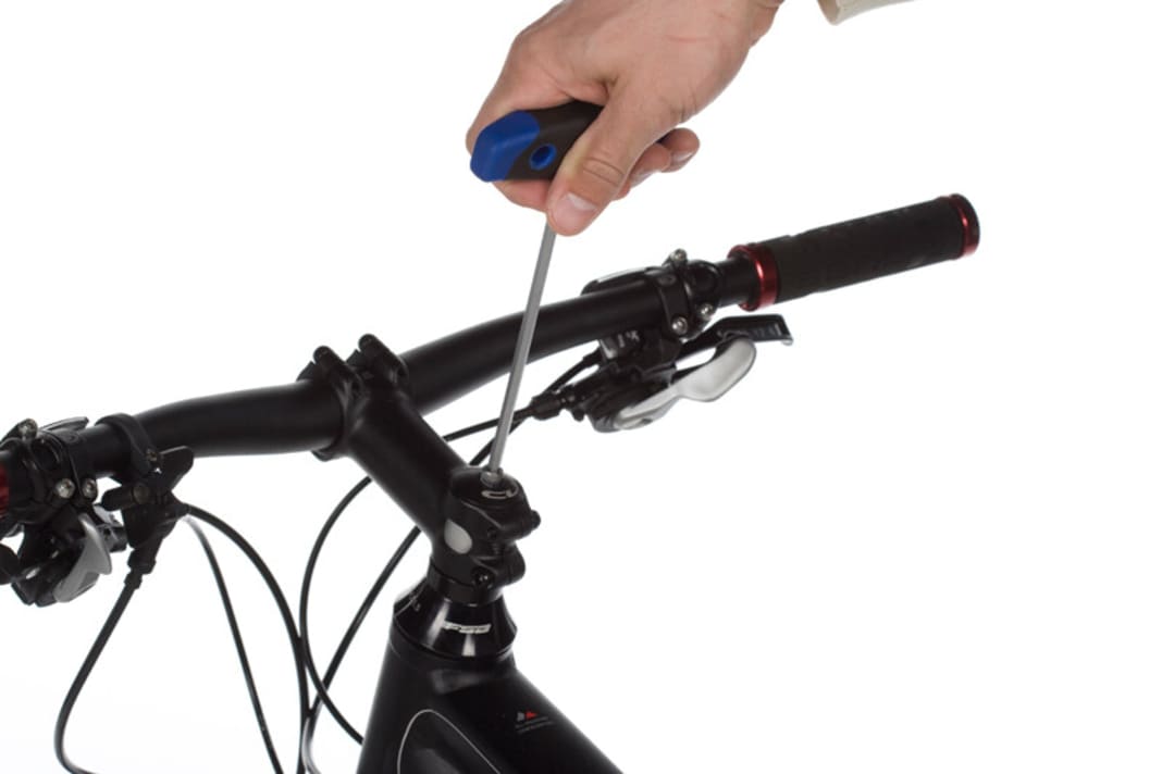 Wenn der Steuersatz trotz perfekter Einstellung einrastet oder Geräusche von sich gibt, ist spätestens ein Service fällig. Spannen Sie dazu das Bike in einen Montage- Ständer und nehmen Sie das Vorderrad heraus. Anschließend öffnen Sie die Ahead-Schraube mit einem Inbus-Schlüssel. Nehmen Sie die Abdeckkappe ab.