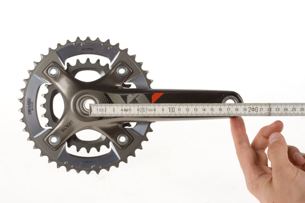 KURBELLÄNGE
Kleine Leute, kleiner Rahmen: Auch die Kurbellänge sollte angepasst werden.

Gemessen wird die Kurbellänge von der Mitte der Tretlagerachse bis zur Mitte der Pedalachse. Am häufigsten sind 175-mm-Kurbeln verbaut, gefolgt von 170ern. Hochwertige Kurbelsysteme, wie die XTR-Kurbeln, bietet Shimano in 2,5-mm-Schritten an.
Kürzer oder Länger? Einflussfaktoren auf die optimale Länge gibt es viele: Körpergröße, Schrittlänge, Vorlieben. Falls Sie nicht mit der Standard-Kurbel zurechtkommen, sollten Sie etwas unternehmen. Dabei gilt: Große (ab 1,90 m) und sportliche Fahrer greifen zur längeren Kurbel, kleine (unter 1,70 m) und mit hoher Trittfrequenz kurbelnde Biker wählen die kürzere Variante.
Bei Knieproblemen sollten Sie kürzere Kurbeln ausprobieren, da so der Bewegungsumfang verringert wird. Fahrer, die gern mit dicken Gängen und niedriger Trittfrequenz in die Pedale treten, sind mit längeren Kurbeln besser beraten, weil die Umlaufstrecke dadurch zunimmt. Nach dem Umstieg aktivieren Sie ungewohnte Muskelbereiche: also langsam beginnen!